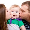Mom and Dad Kissing Baby